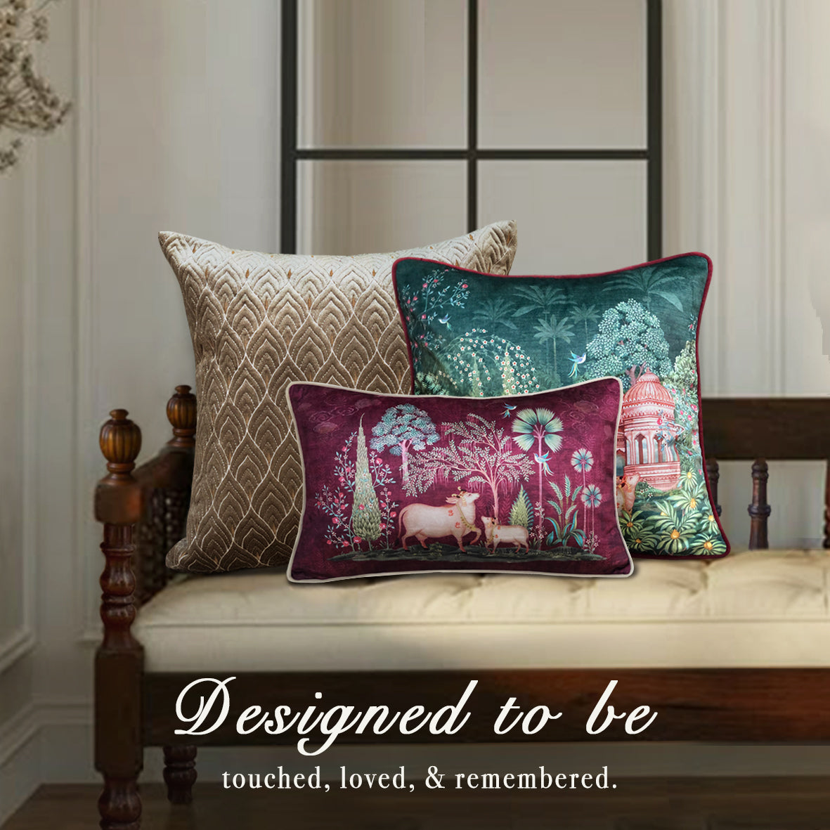Preetier luxury designer cushion covers – elegant beige velvet cushion with gold pattern, teal botanical cushion, and maroon Pichwai art cushion featuring cows and temple, styled on a vintage wooden bench in a classic living room.