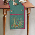 Aqua blue botanical table runner featuring an intricate deer motif, delicate floral illustrations, and a contrasting berry-pink border, showcasing the Whispering Grove design by Preetier.