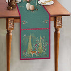 Aqua blue botanical table runner featuring an intricate deer motif, delicate floral illustrations, and a contrasting berry-pink border, showcasing the Whispering Grove design by Preetier.