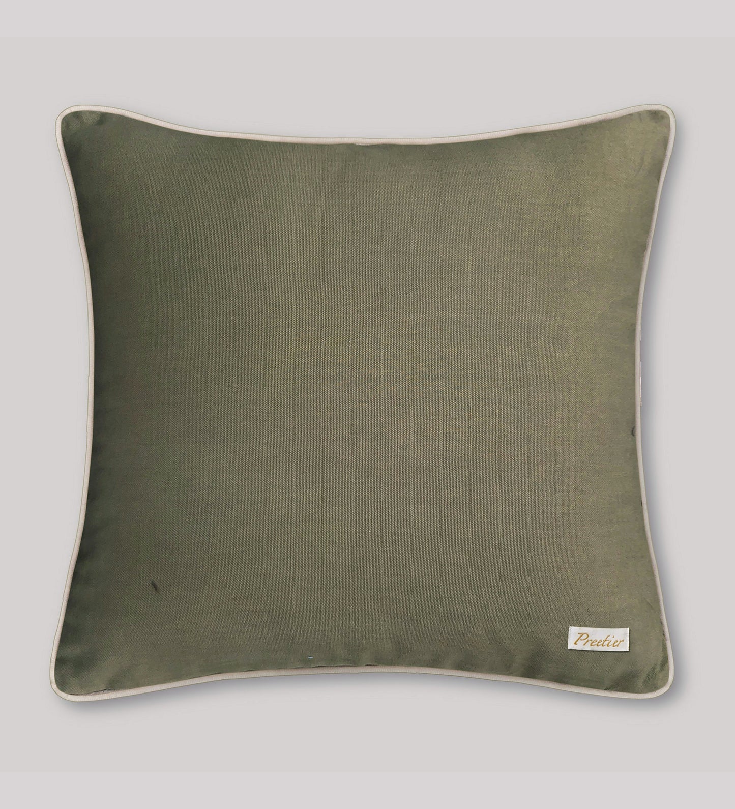Green pillow with a brand label on a light gray background
