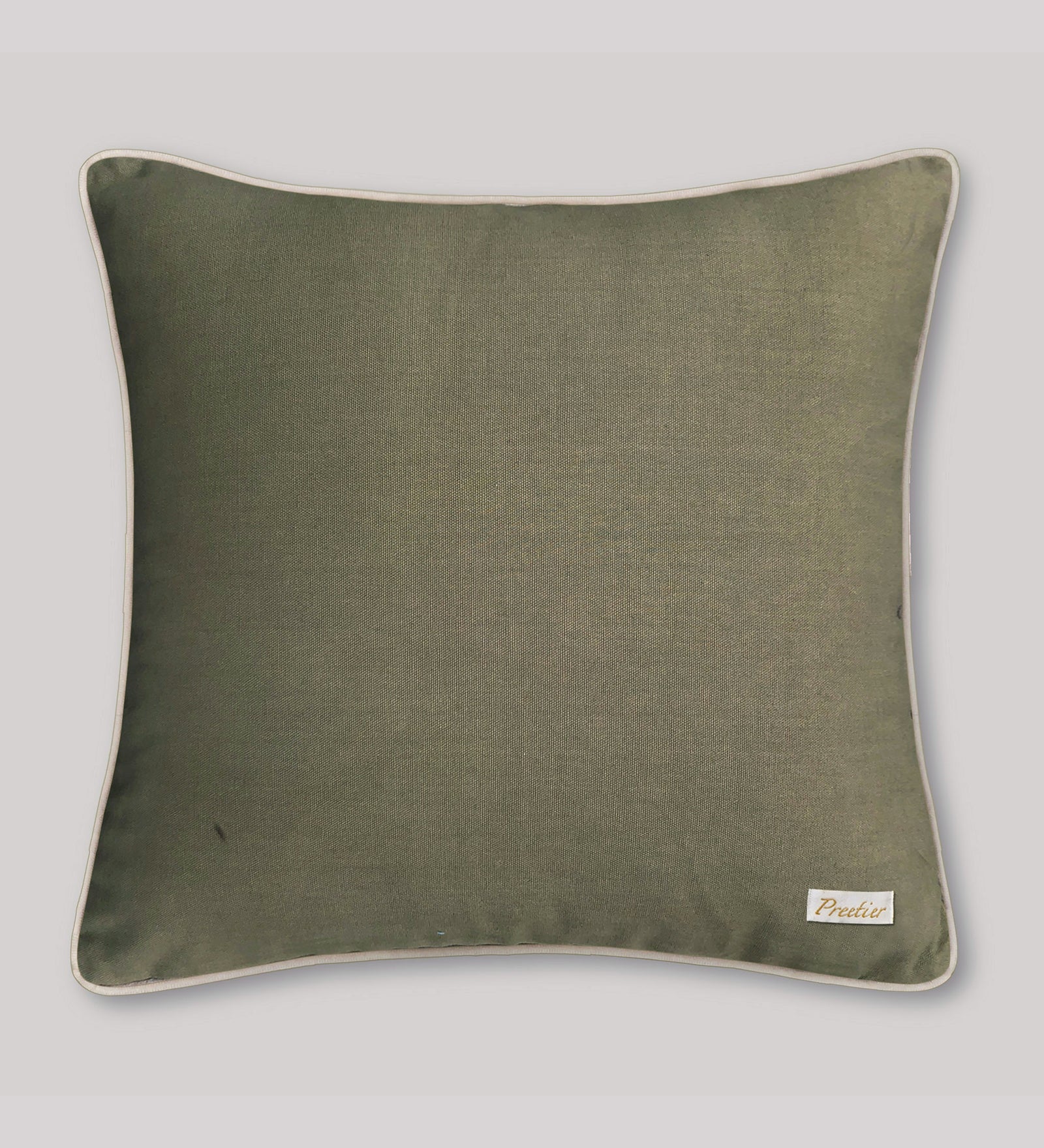 Green pillow with a brand label on a light gray background