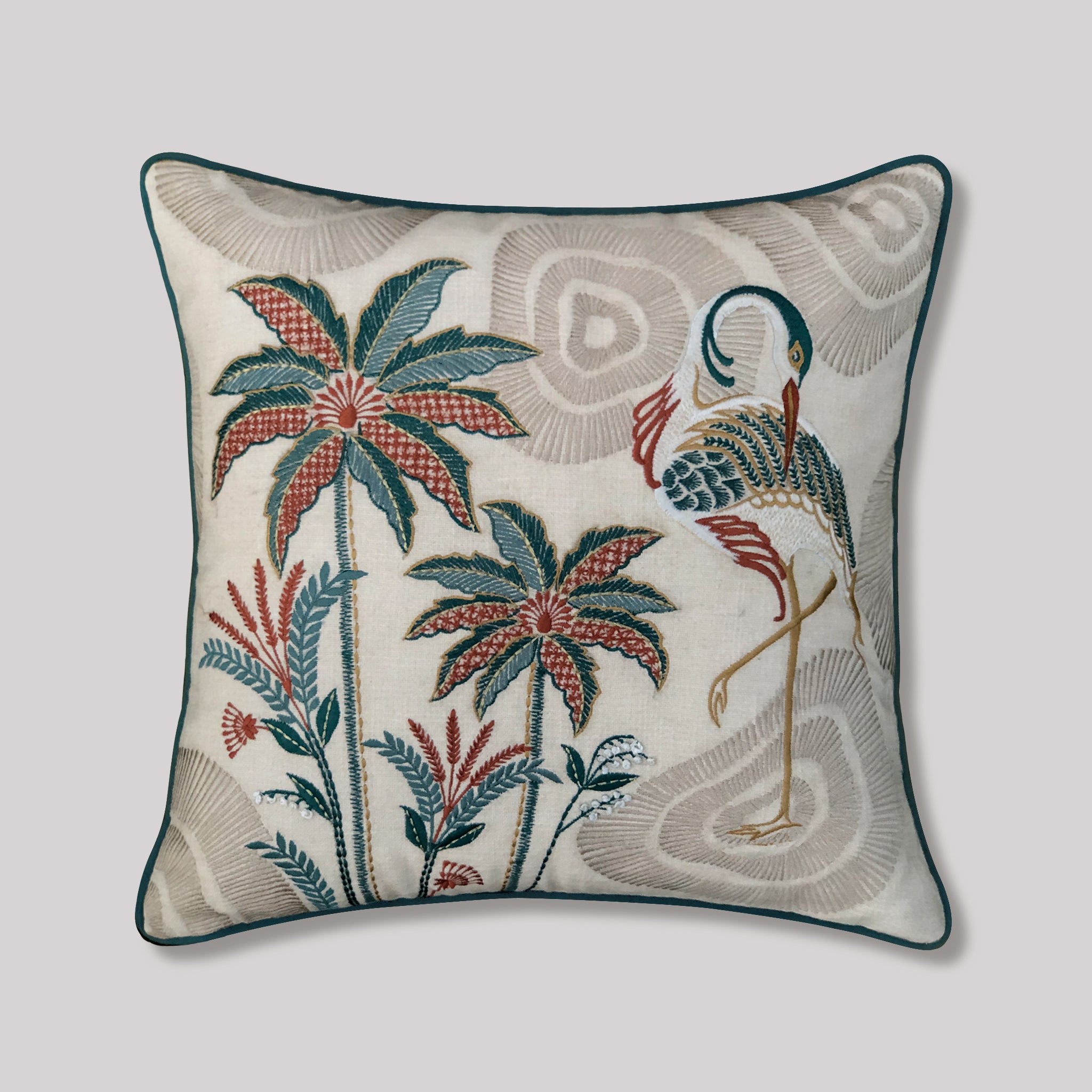 Luxury cream cushion cover featuring detailed botanical embroidery of a crane bird standing amongst tropical palm trees. The design showcases intricate heritage-inspired threadwork with a deep rust-colored velvet backing