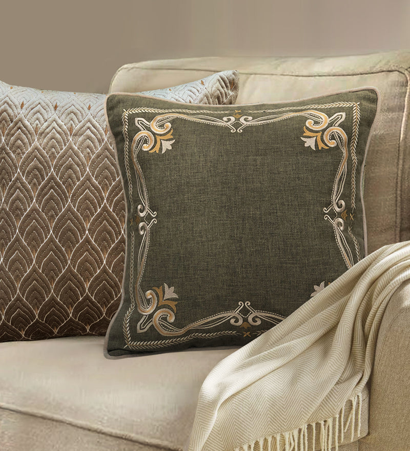 Green cotton cushion with gold embroidered border, styled as a luxury sofa pillow for modern living room decor.