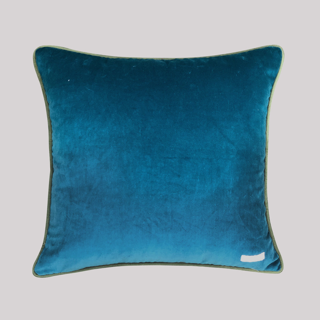A luxury 18x18 inch embroidered crane pillow styled on a modern sofa, showcasing the rich jewel-toned teal fabric and intricate floral botanical patterns.