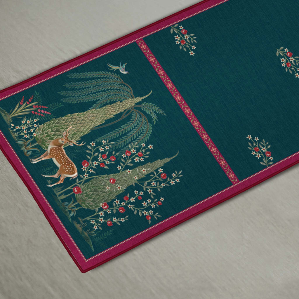 Whispering Grove designer table runner in teal blue with nature-inspired artwork and contrasting pink borders, styled with elegant tableware and decorative accents for a refined dining setting.