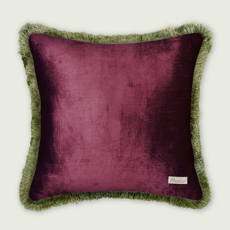 Purple pillow with green fringes on a white background